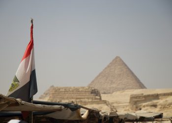 an egyptian flag flying in front of the pyramids of giza